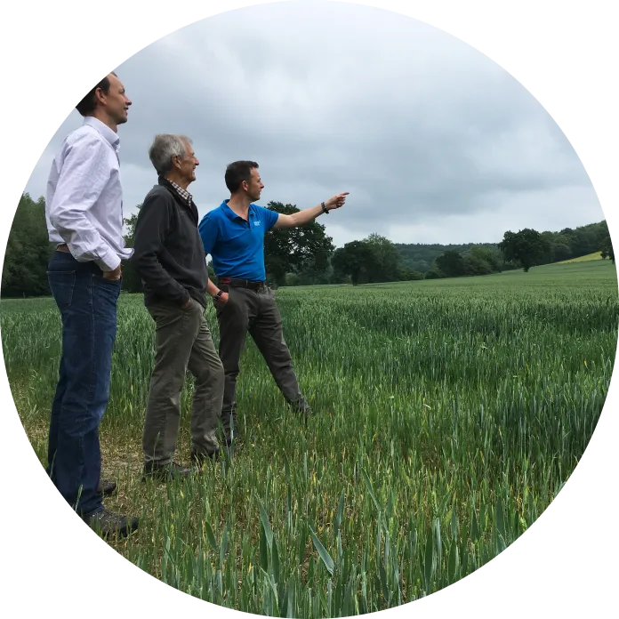 three generations of the family owner assess the farm land around the spring