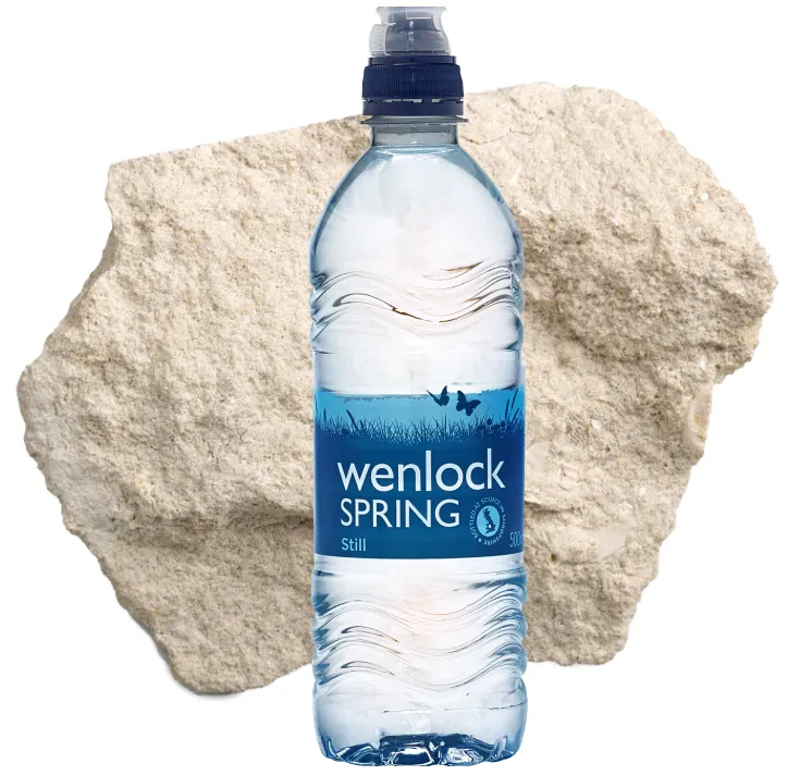 a bootle of wenlock spring mineral water infront of a large chunk of wenlock limestone